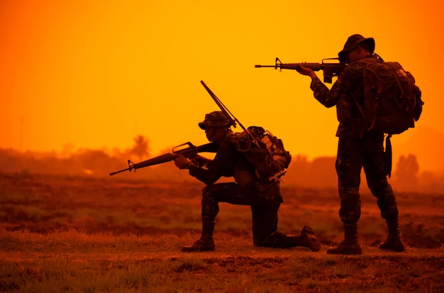 Team speciale krachten. Soldaat assault rifle met geluiddemper. Silhouet actie soldaten houden wapens. Militair en gevaar concept.