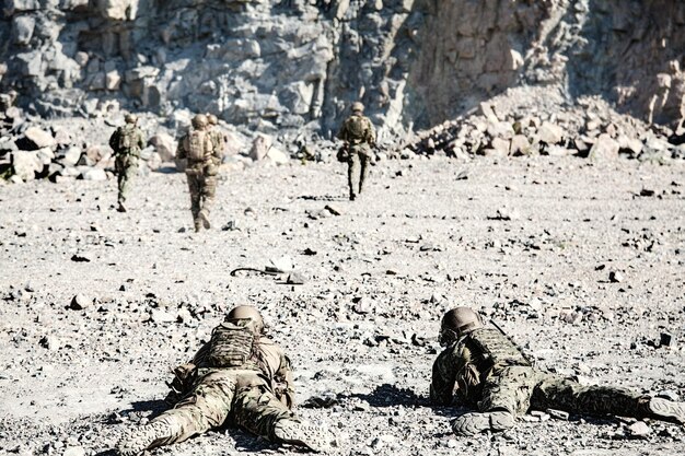 Team squad of special forces in action in the desert among the rocks