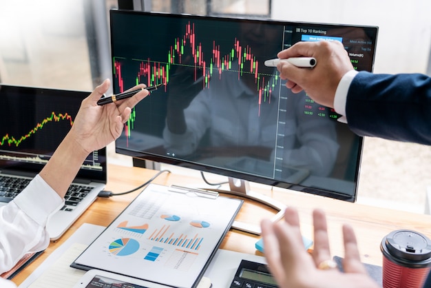 Photo team of stockbrokers discussing with display screens