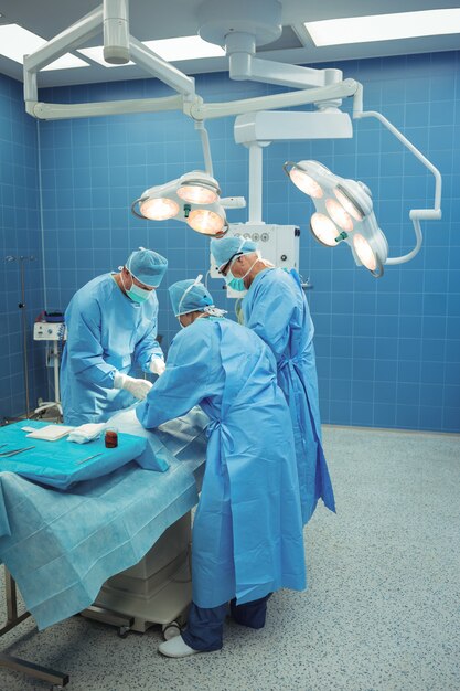 Команда хирургов, выполняющих операции в операционном зале