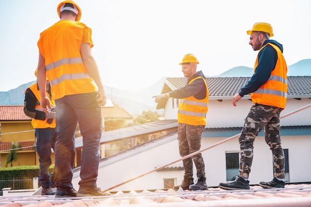 Un team di tecnici lavora sul tetto di una casa