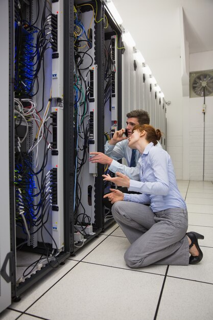 Team of technicians kneeling and looking at servers