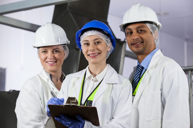 Team of technicians standing in meat factory