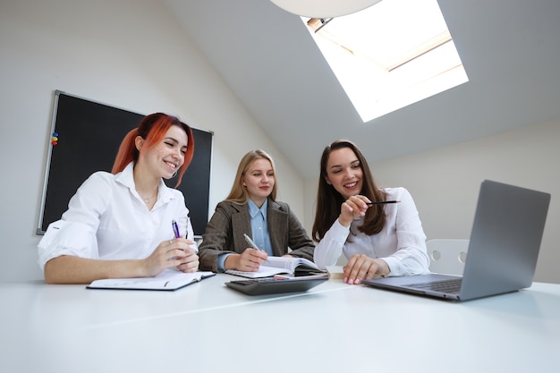 A team of three female businessmen discuss work plans