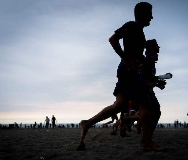 Photo team training of young boys on the sunset beach