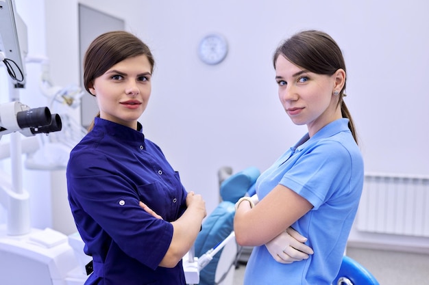 Team of two doctors women dentists in the dental office, female colleagues look at camera. Medicine, dentistry and health care concept