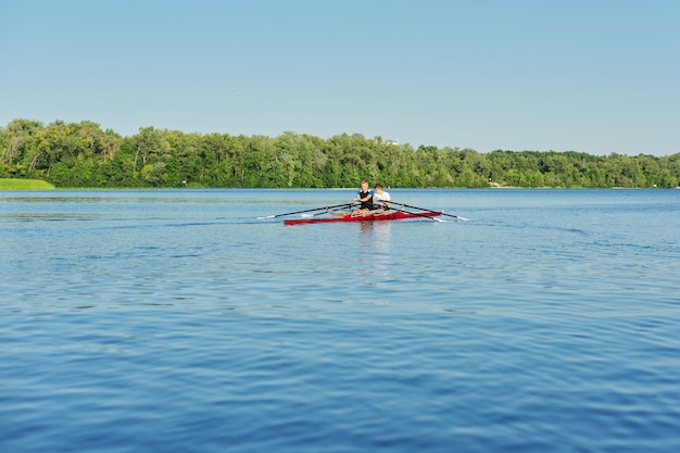 Team of two teenage boys kayaking on river. Active youth lifestyle, water sports, kayak, canoe