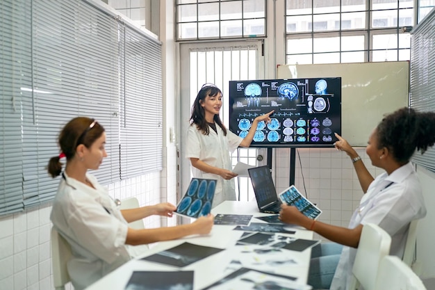 Team van artsen bespreken resultaten van XRay of MRI-scan van de hersenen van de patiënt in het medicijnkantoor van de kliniek