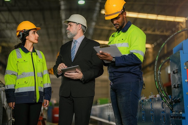 Team van ingenieurs controleren controle zware machine in fabriek Senior baas manager inspecteert met personeel ingenieurs vrouw en Afrikaanse man Concept Engineer Bediening en controle in fabriek met veiligheid