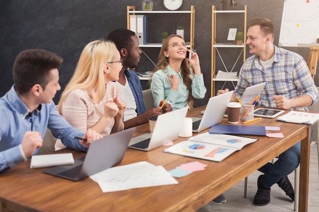 Team van jonge programmeurs die werken in een softwareontwikkelingsbedrijf, typen op laptops, nieuwe games of apps testen, ruimte kopiëren