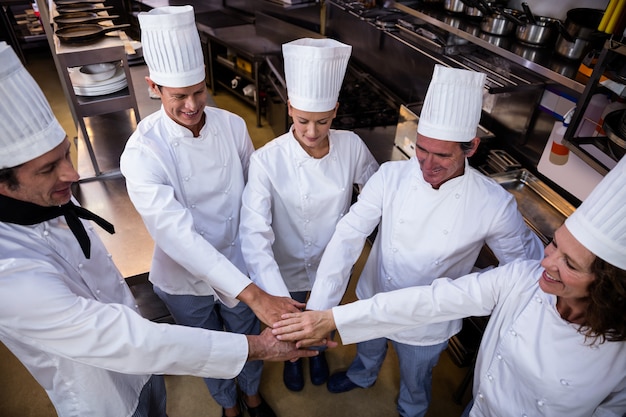 Team van koks die handen samenbrengen