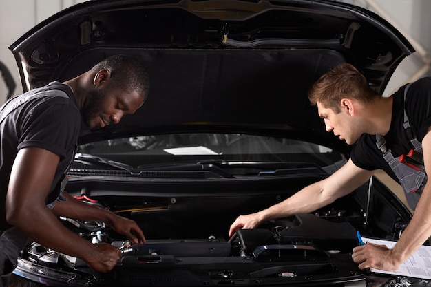 Team van mannen aan het werk in auto-servicewinkel