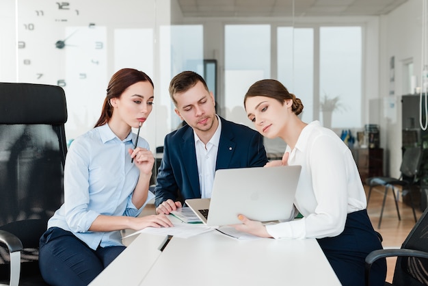 Team van professionals kijken naar laptop en zaken bespreken op kantoor