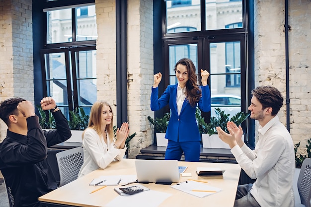 Team van succesvolle ondernemers vieren aan tafel op kantoor