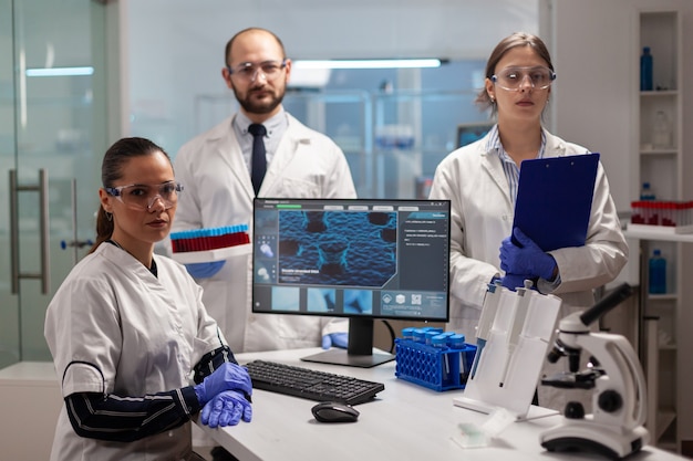 Team van wetenschappers die in het laboratorium zitten en naar de camera kijken in een modern lab
