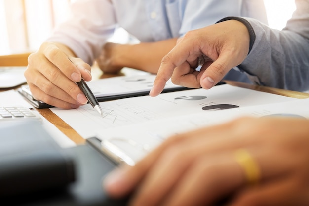 Team werk proces. jonge zakenmanagers die werken met een nieuw opstartproject. labtop op houten tafel, toetsenbord typen, sms-bericht, grafiekplannen analyseren.