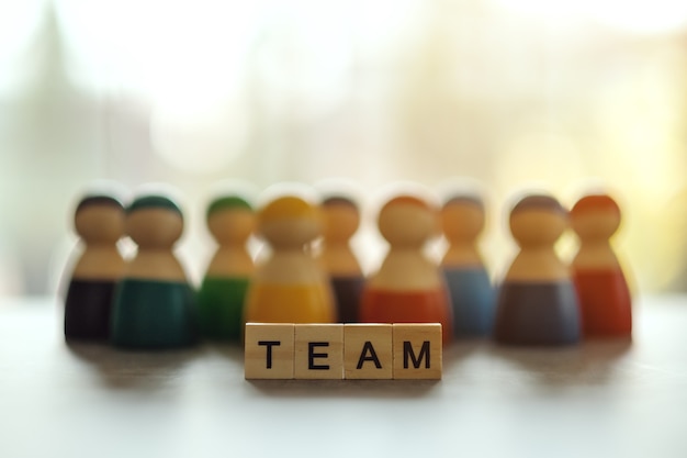 Photo team word on wooden blocks with  a group of people in the background