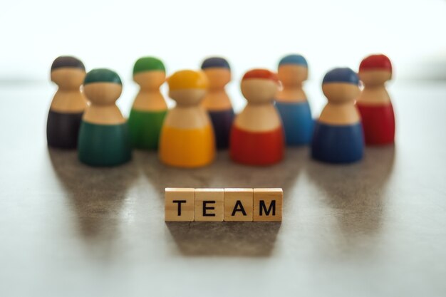 TEAM word on wooden blocks with  a group of people in the background