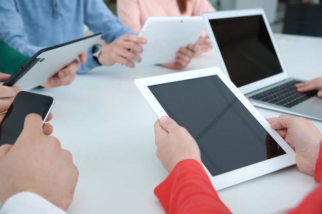 Team work concept. People sitting at table in office and using digital devices