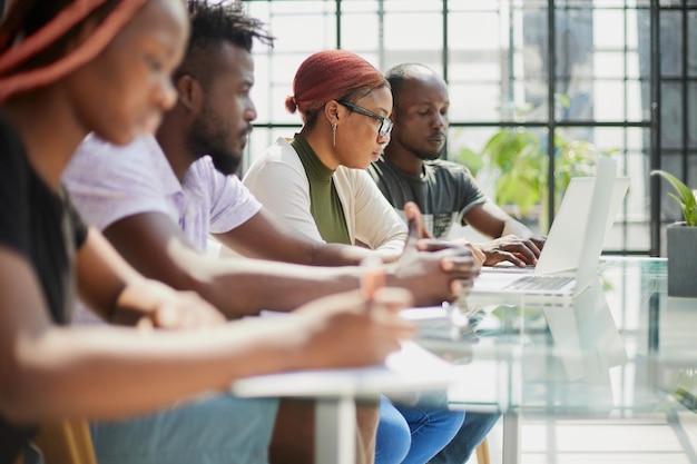 Team of young african people in the office at the table with a laptop