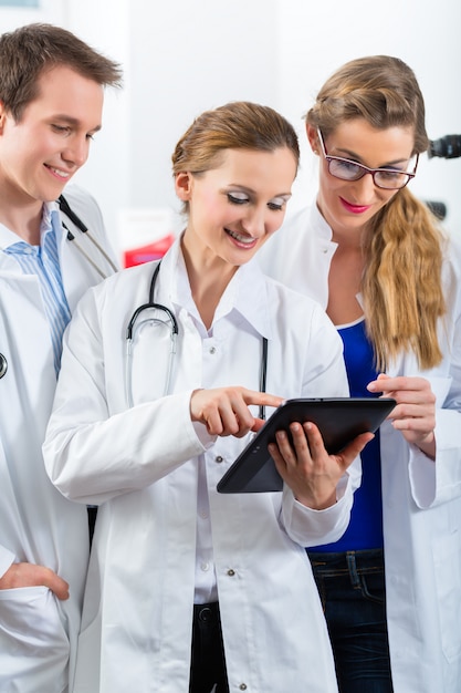 태블릿 컴퓨터와 병원에서 젊은 의사의 팀