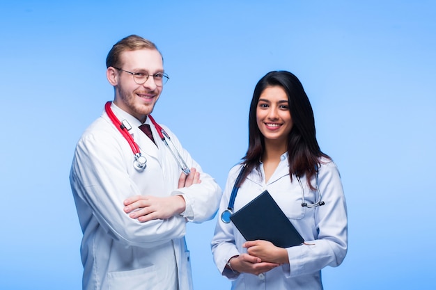 A team of young doctors. Multinational people - doctor, nurse and surgeon in blue background. A group of medical students of different nationalities are looking in the cell.