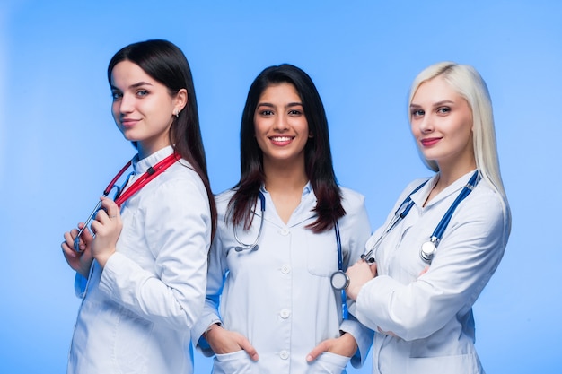 A team of young doctors. Multinational people - doctor, nurse and surgeon in blue background. A group of medical students of different nationalities are looking in the cell.