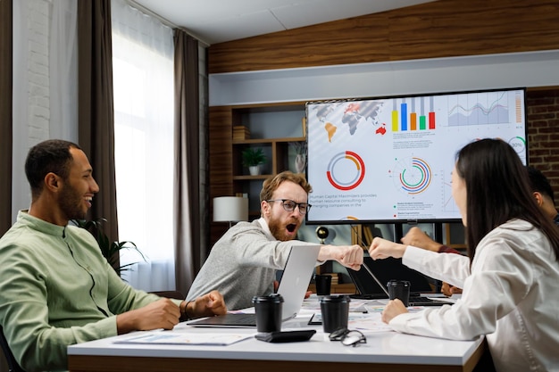 Foto un team di giovani uomini d'affari di razza mista che lavorano in una startup si rallegra per il tè della strategia aziendale di successo