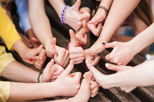 Squadra di giovani donne sedute insieme e tenendosi per mano