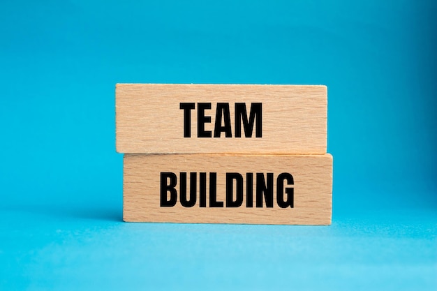 Teambuilding boodschap geschreven op houten blokken met blauwe achtergrond Conceptueel teambuilding symbool Kopieer ruimte