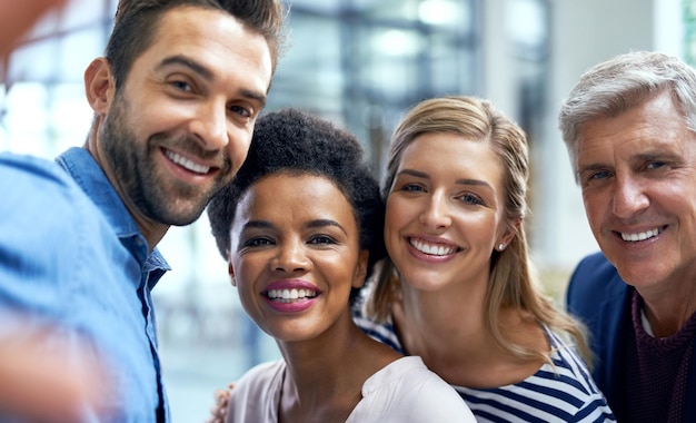 Teamsucces vieren met een selfie Shot van een groep collega's die samen een selfie maken in een modern kantoor