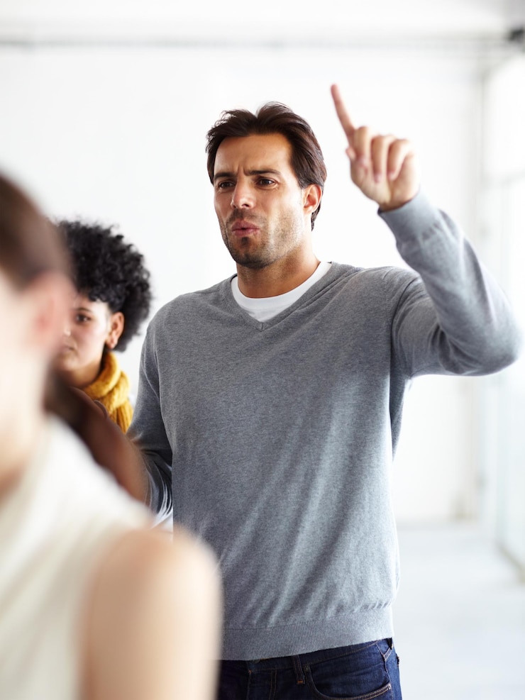Foto teamvergadering en man met twijfel vraag en gefrustreerd werknemer protesteert bij creatief agentschap workshop human resources en zakenlieden op seminar met hand omhoog woede en verward op kantoor