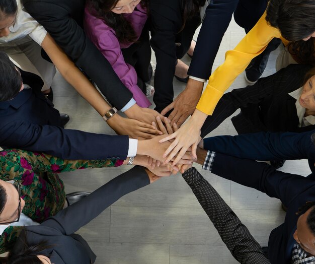 Teamwerk en eenheidsconcept Diverse team dat handen in elkaar steekt Groep van verschillende zakenmensen