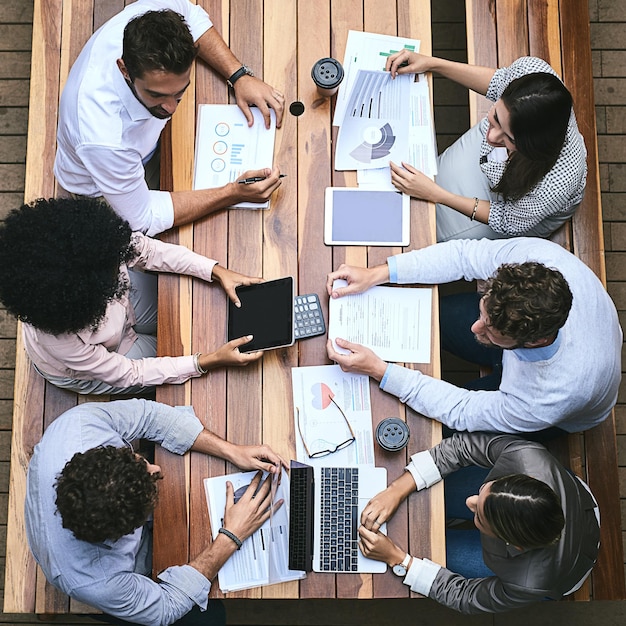 Teamwerk en technologie is alles wat ze nodig hebben om te slagen Hoge hoekopname van een team zakenmensen die buiten een vergadering hebben