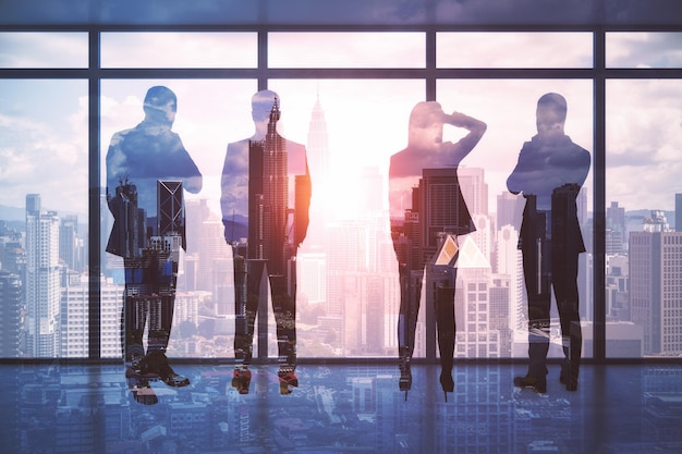 Teamwerk en zakelijk partnerschap concept met zakenlieden silhouetten op hoge verdieping wolkenkrabber kijkend door transparante glazen wand op megapolis stad bij zonsondergang