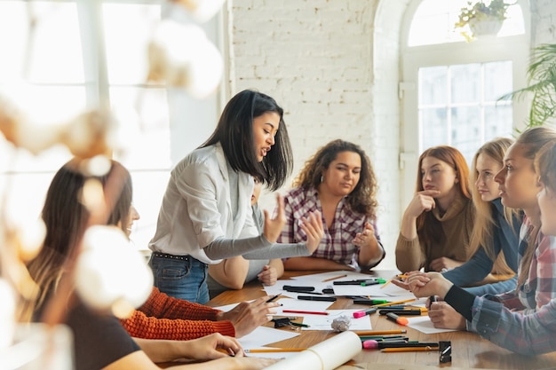 Teamwerk. jongeren discussiëren over vrouwenrechten en gelijkheid op kantoor. blanke zakenvrouwen of kantoormedewerkers hebben een ontmoeting over problemen op de werkplek, mannelijke druk en intimidatie.