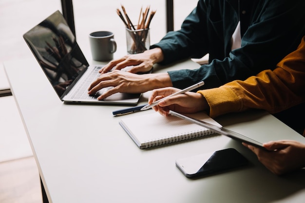 Teamwerk van Aziatische zakenmensen die met een rekenmachine discussiëren en berekenen over evaluatiegegevens in vergaderruimte met de groei en wijzend naar de financiële rekening van de grafiekgrafiek