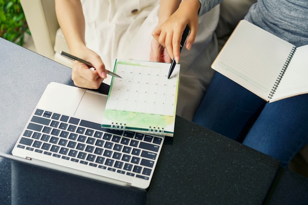 Foto teamwerkbijeenkomst, vrouwen praten met planningsagenda en schema met agenda-afspraak