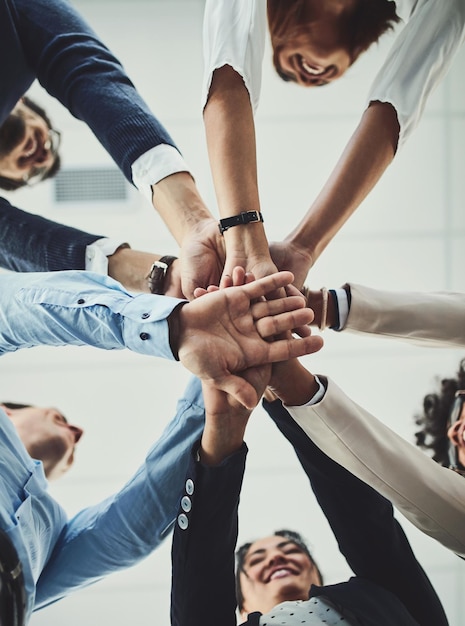 Teamwerksamenwerking en eenheid tussen zakenmensen met hun handen gestapeld voor projectontwikkeling en innovatie Groep bedrijfscollega's verenigd toetreden of samenwerken van onderaf