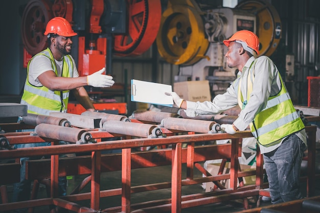 Teamwork Afro-Amerikaanse zwarte man is arbeider en werkt in een zware metalen fabriek