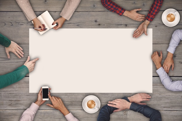 写真 チームワークと協力の概念-木製のテーブルの上の大きな白い白紙に描いたり書いたりする6人の平面図。