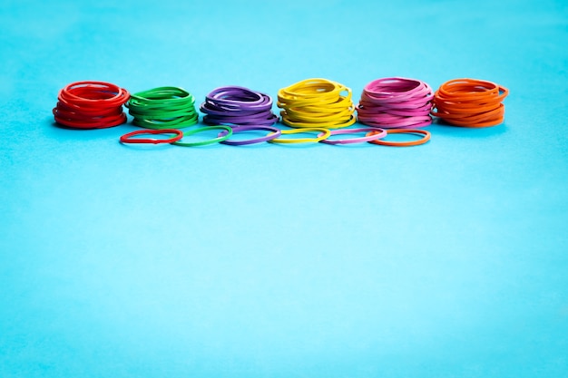 Teamwork concept group of colorful rubber band on blue background with copy space