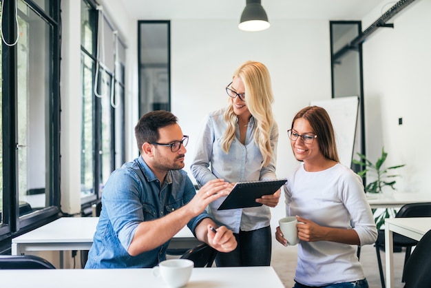 팀워크 개념입니다. 현대 coworking 사무실에서 일하는 세 젊은 사람들.