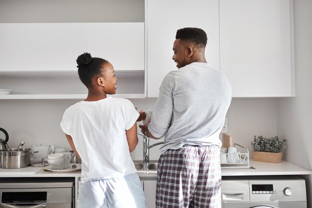 Teamwork and cooperation keeps a home clean Shot of a young couple washing the dishes together at home