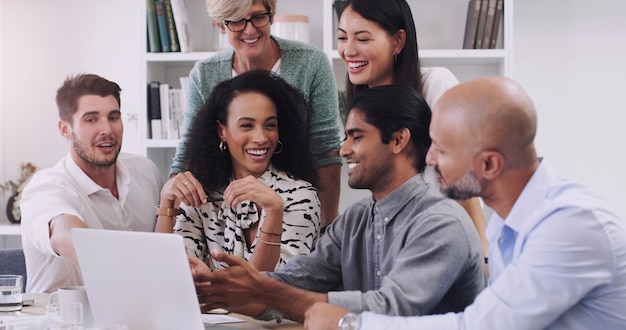 Teamwork has the power to inspire positive change Shot of a group of businesspeople using a laptop in a modern office