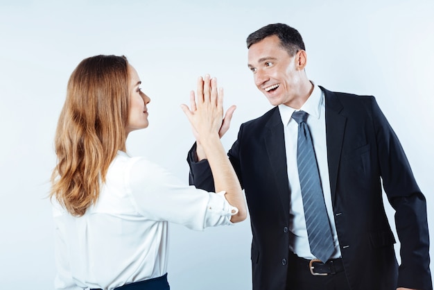 Teamwork is het droomwerk. Een foto van positieve collega's die praten terwijl ze elkaar een high five geven na hun succesvolle project.