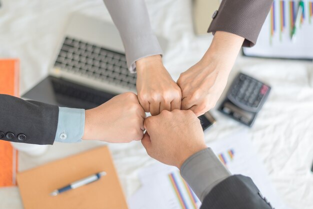 Teamwork join hands, close-up of business partners making pile\
of hands at meeting, business concept.