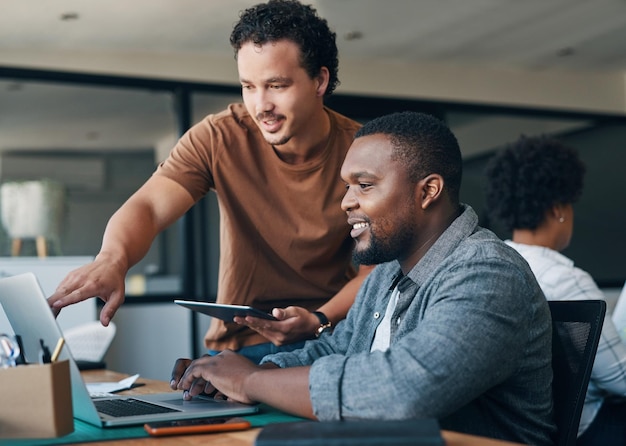 Il lavoro di squadra rende tutto più semplice inquadratura di due giovani uomini d'affari che lavorano insieme in un ufficio