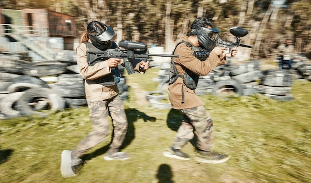 Foto velocità del lavoro di squadra e paintball con l'uomo in gioco per giochi di guerra e sportivi nel parco giochi sfida la missione e il soldato con le persone che sparano nell'arena del campo di battaglia per la pistola bersaglio e l'addestramento dei guerrieri