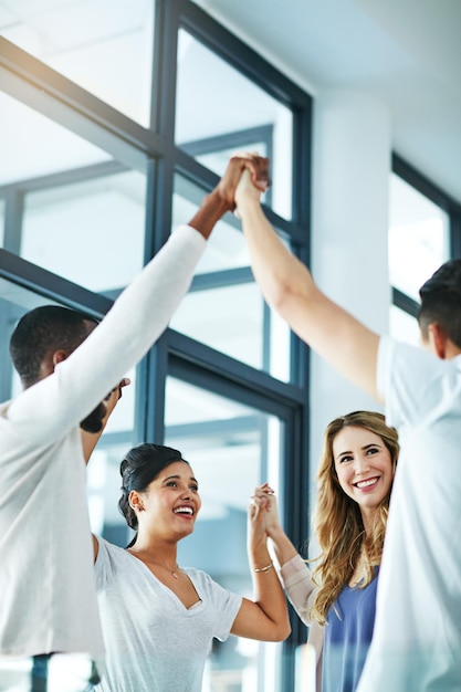 Supporto al lavoro di squadra e divertimento al lavoro con un felice gruppo di uomini d'affari che si godono un'attività di team building diversi colleghi si uniscono per mostrare la comunità che collabora mentre sorridono e parlano